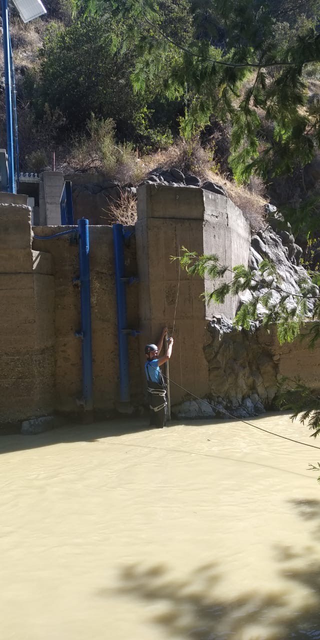 Profesional midiendo en una estructura hidráulica de hormigón