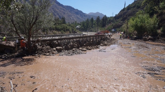 Puente provisorio sobre un cauce con flujo de barro